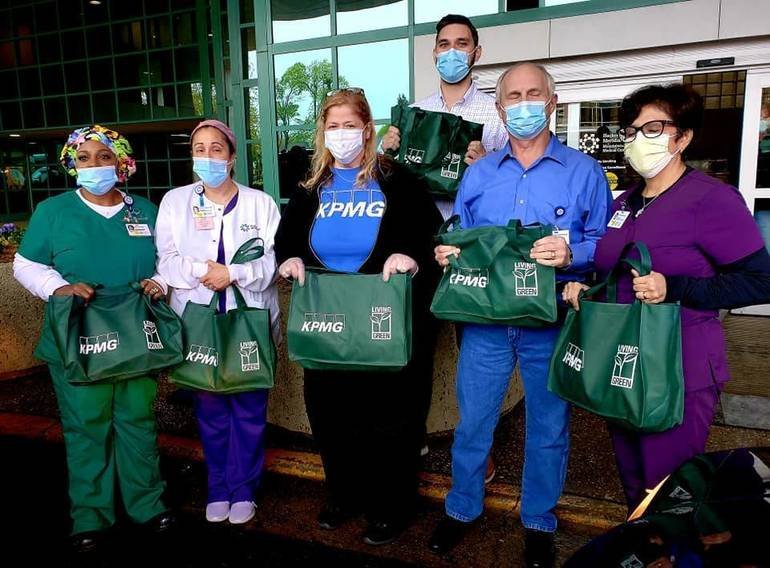 A group of medical workers wearing masks and holding tote bags.