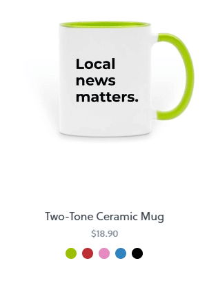 A white coffee muh with a green handle and black text in the middle that reads, "Local news matters."
